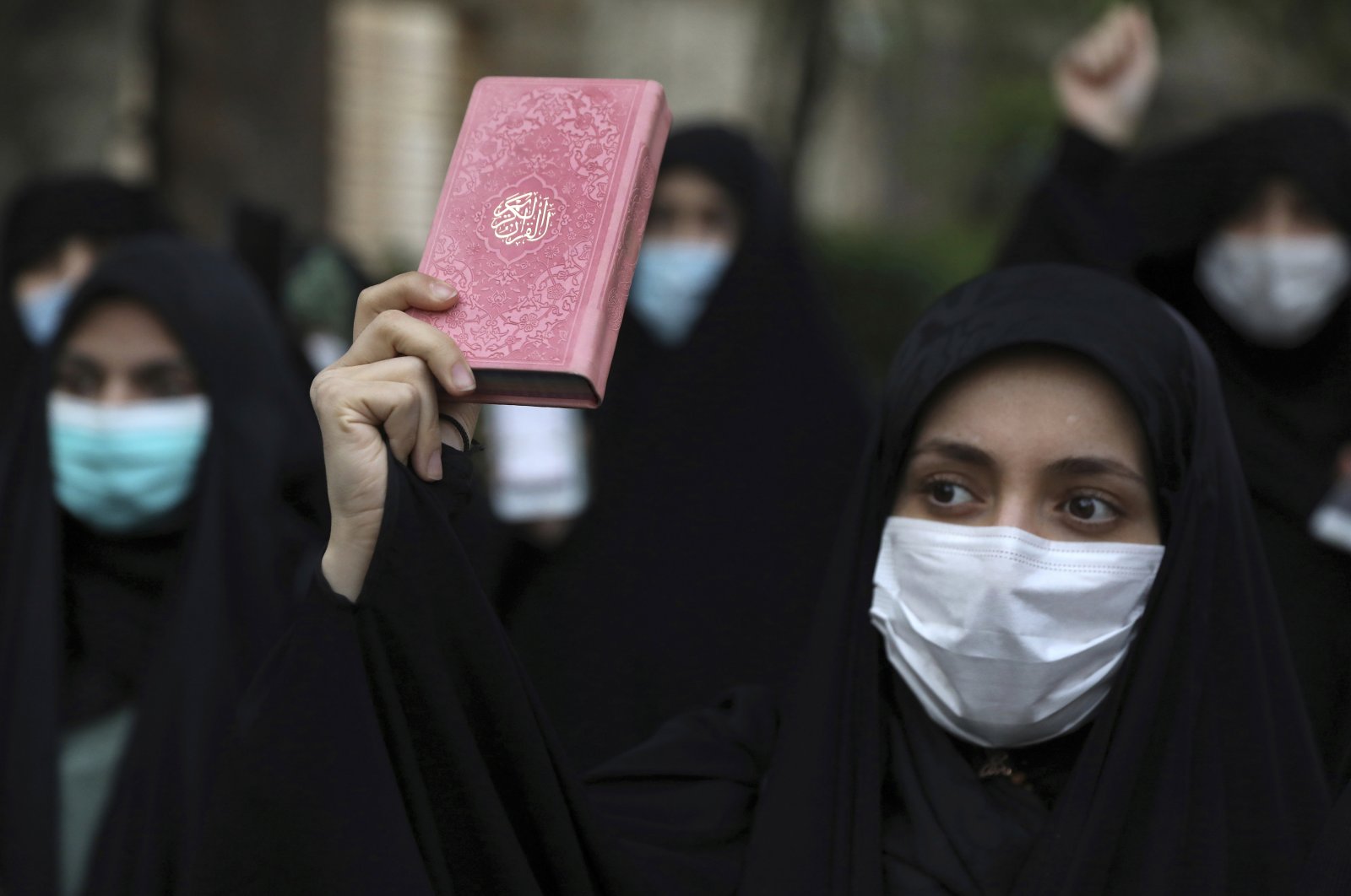 A protester holds a copy of the Quran during a demonstration to condemn planned burnings of the holy book in Sweden, in front of the Swedish Embassy in Tehran, Iran, April 18, 2022. (AP Photo)