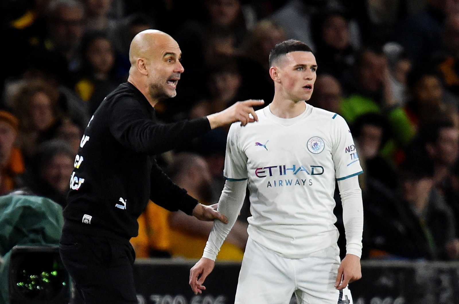 Man City manager Pep Guardiola talks to Phil Foden during a Premier League match against Wolves, Wolverhampton, England, May 11, 2022. (Reuters Photo)