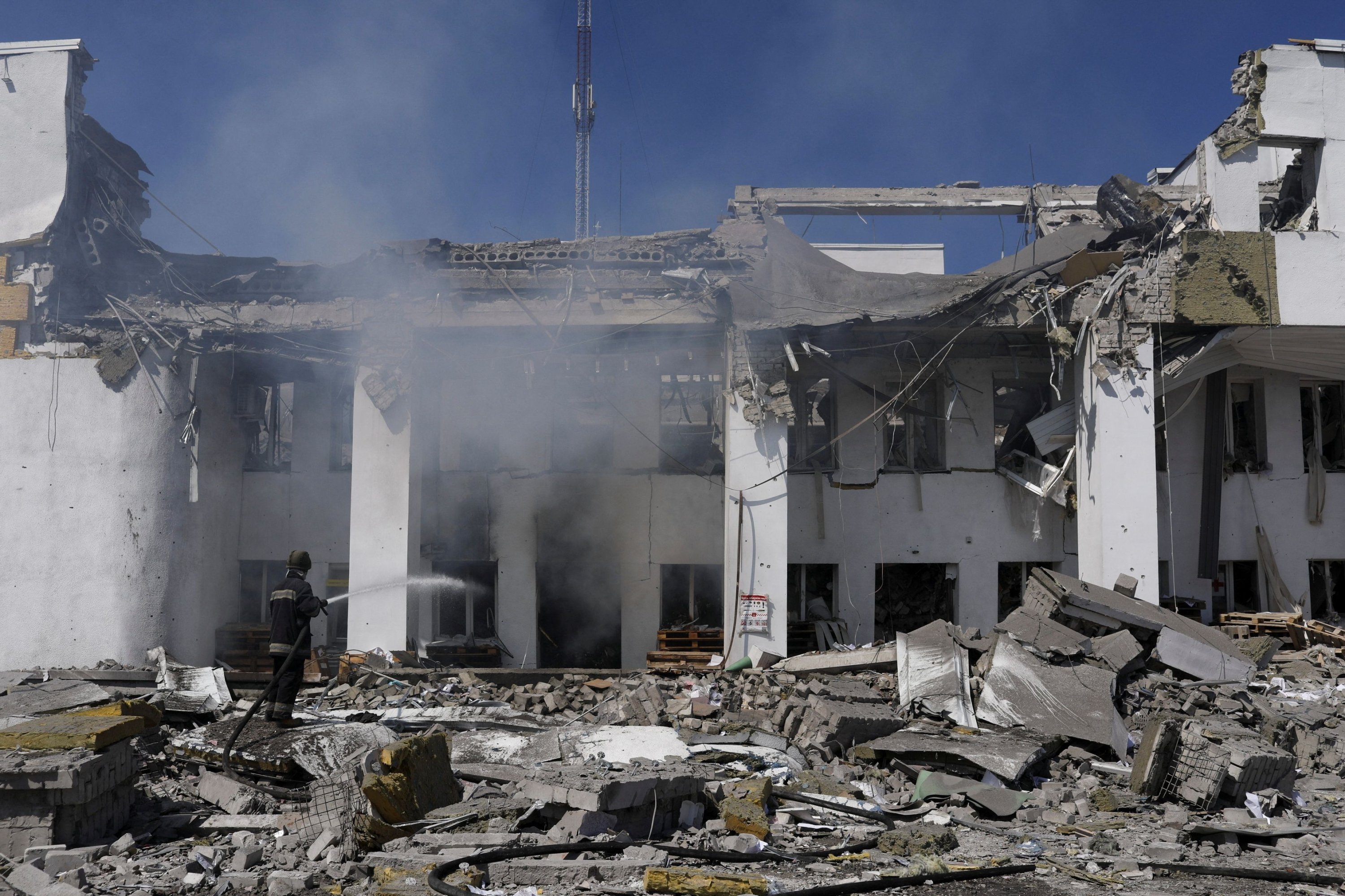 13 Mayıs 2022'de Ukrayna'nın Kharkiv kenti yakınlarındaki Derhachi'de Rusya'nın Ukrayna'ya düzenlediği saldırı sırasında yardım dağıtmak için kullanılan Kültür Evi'ne bir Rus bombalı saldırısının ardından çıkan yangını söndürmek için bir itfaiyeci çalışıyor. (Reuters Fotoğraf)