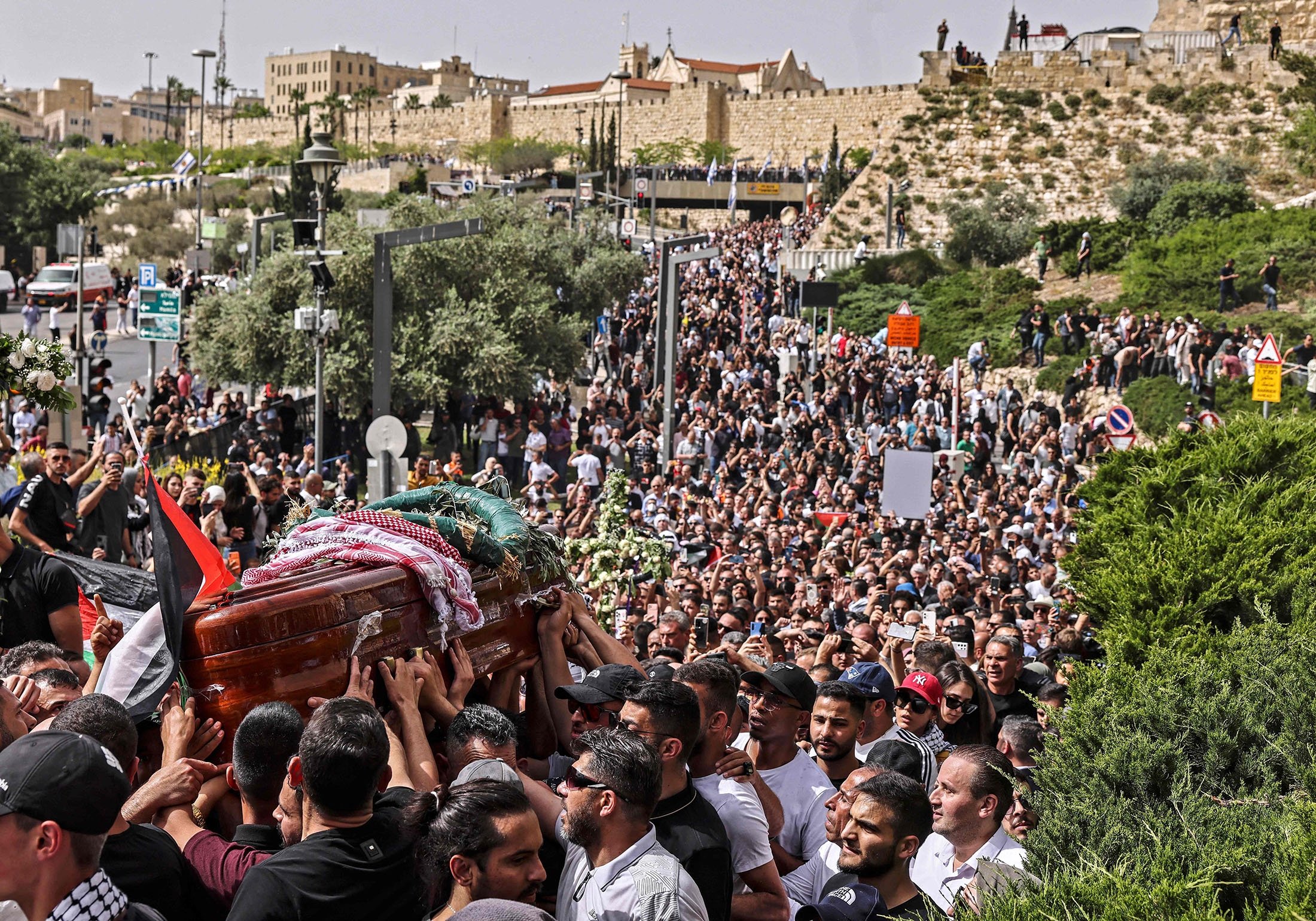Filistinli yaslılar, öldürülen El Cezire gazetecisi Shireen Abu Aklel'in tabutunu bir kiliseden mezarlığa doğru taşıyorlar, 13 Mayıs 2022'de işgal altındaki Filistin'de Doğu Kudüs'teki cenaze alayı sırasında. (AFP Photo)