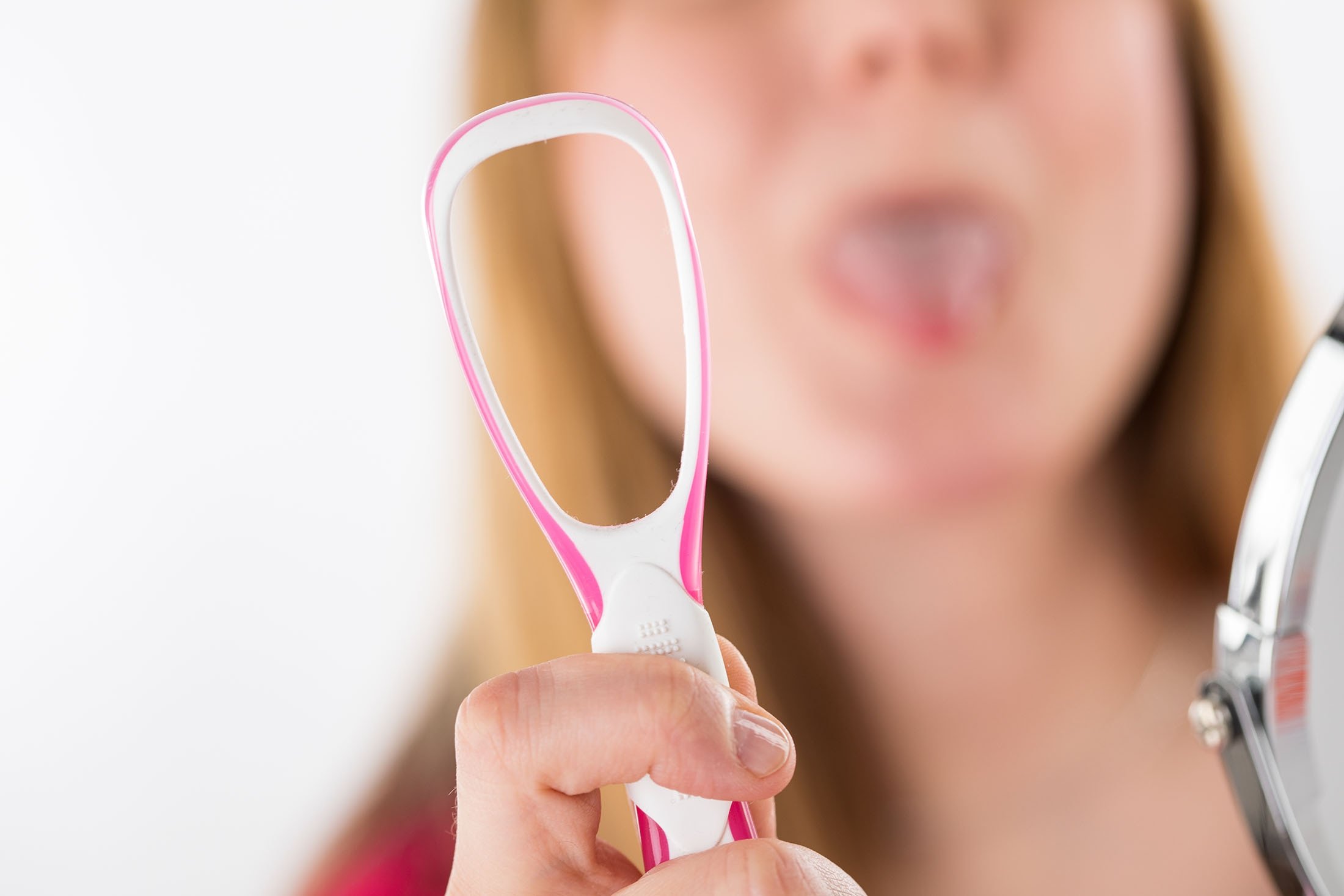 Menggunakan scraper lidah mengurangi bakteri dan membantu mencegah halitosis.  (DPA)