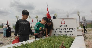 Children visit the grave of one of the victims of the Edebük Massacre, Erzincan, Turkey, May 15, 2022. (IHA Photo)