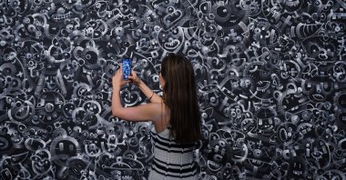 A woman takes a picture of &quot;Sharon,&quot; one of the pieces on display at Sotheby&#039;s in London, for Robbie Williams and his creative partner, Ed Godrich&#039;s debut exhibition. (DPA Photo)