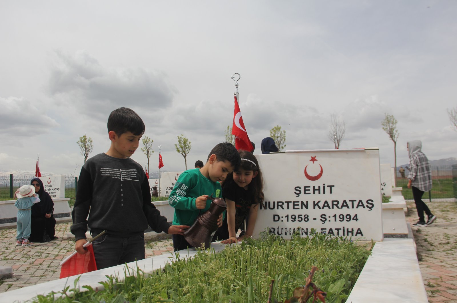 Children visit the grave of one of the victims of the Edebük Massacre, Erzincan, Turkey, May 15, 2022. (IHA Photo)
