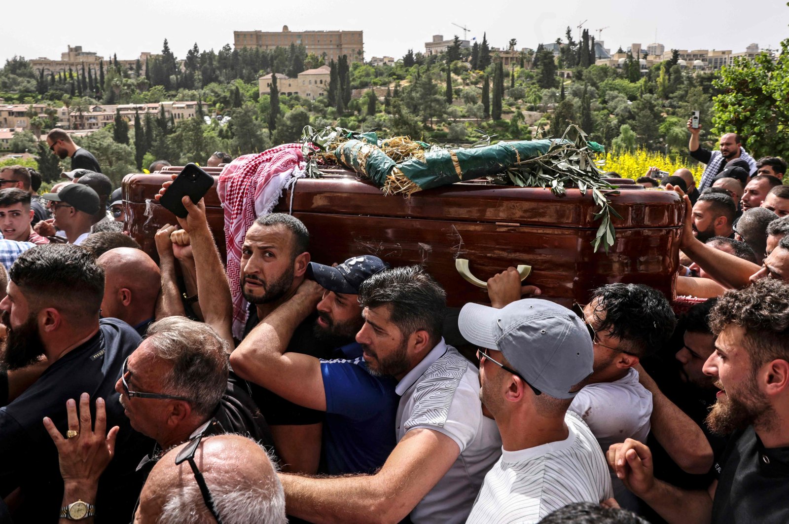Palestinian mourners carry the coffin of slain Al-Jazeera journalist Shireen Abu Akleh towards the Mount Zion cemetery following a church service in Jerusalem on May 13, 2022. (AFP Photo)