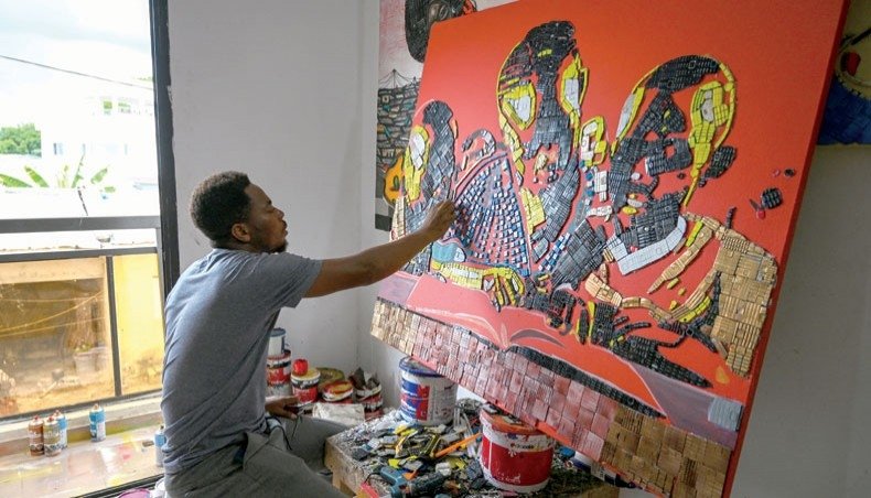 Ivorian artist Mounou Desire Koffi makes an artwork with used telephone keyboards at his residence in Bingerville, a commune of Abidjan, Ivory Coast, April 28, 2022. (AFP Photo)