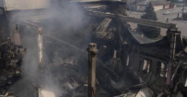 A Ukrainian firefighter works inside a destroyed cultural center in Derhachi, eastern Ukraine, May 15, 2022. (AP Photo)
