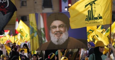 Hezbollah supporters wave portraits of Hezbollah leader Sayyed Hassan Nasrallah and their group flags, during an election campaign, in the southern suburb of Beirut, Lebanon, May 10, 2022. (AP Photo)