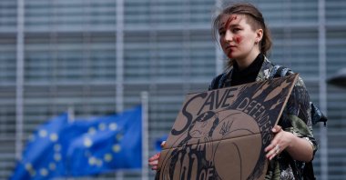 A woman takes part in a rally to call EU countries to "stop buying Russian gas and save defenders of Azovstal" as EU foreign ministers hold a meeting over the war in Ukraine, near the European Council headquarters in Brussels, Belgium, May 16, 2022. (AFP Photo)