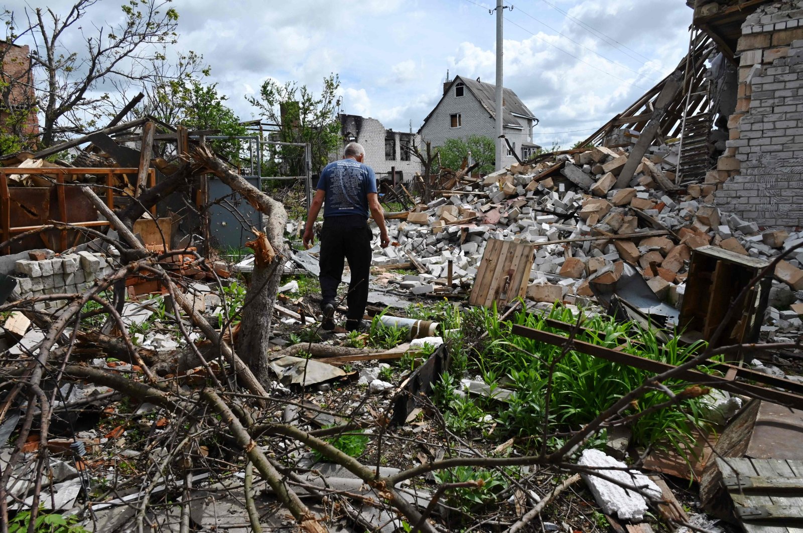  A local resident walks among debris in a yard of his destroyed house in the village of Mala Rogan, east of Kharkiv, on May 15, 2022, amid the Russian invasion of Ukraine. (Photo by SERGEY BOBOK / AFP)