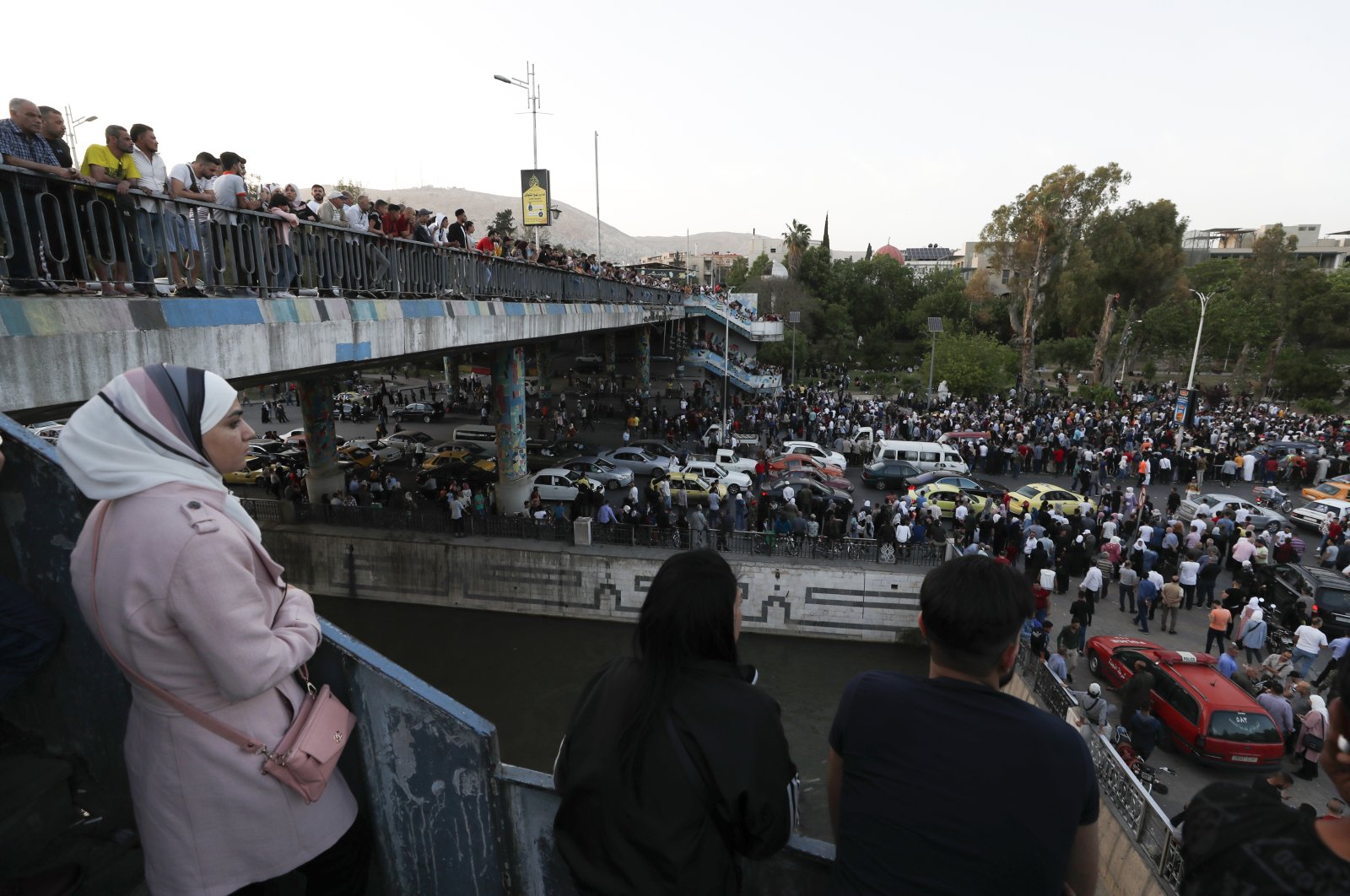 Dozens of Syrians wait at the President&#039;s Bridge in Damascus for relatives they hope would be among those released from prison, Syria, May 3, 2022. (AP Photo)