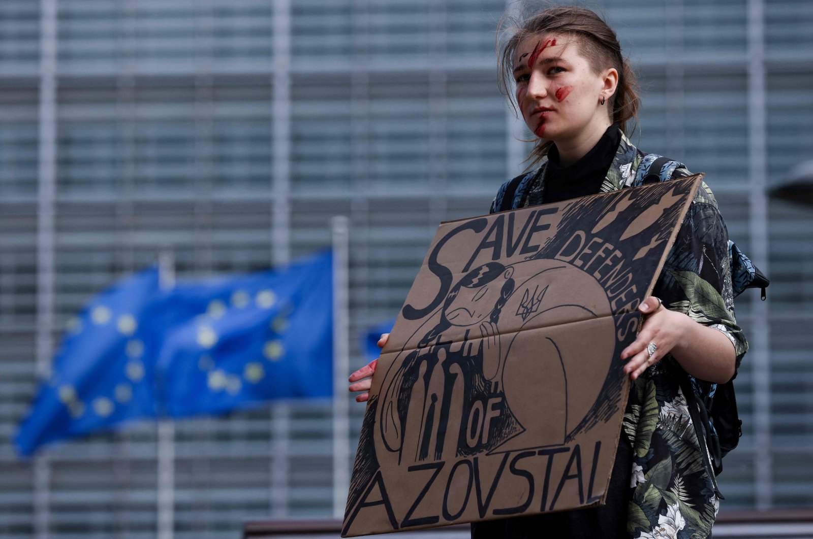 A woman takes part in a rally to call EU countries to "stop buying Russian gas and save defenders of Azovstal" as EU foreign ministers hold a meeting over the war in Ukraine, near the European Council headquarters in Brussels, Belgium, May 16, 2022. (AFP Photo)