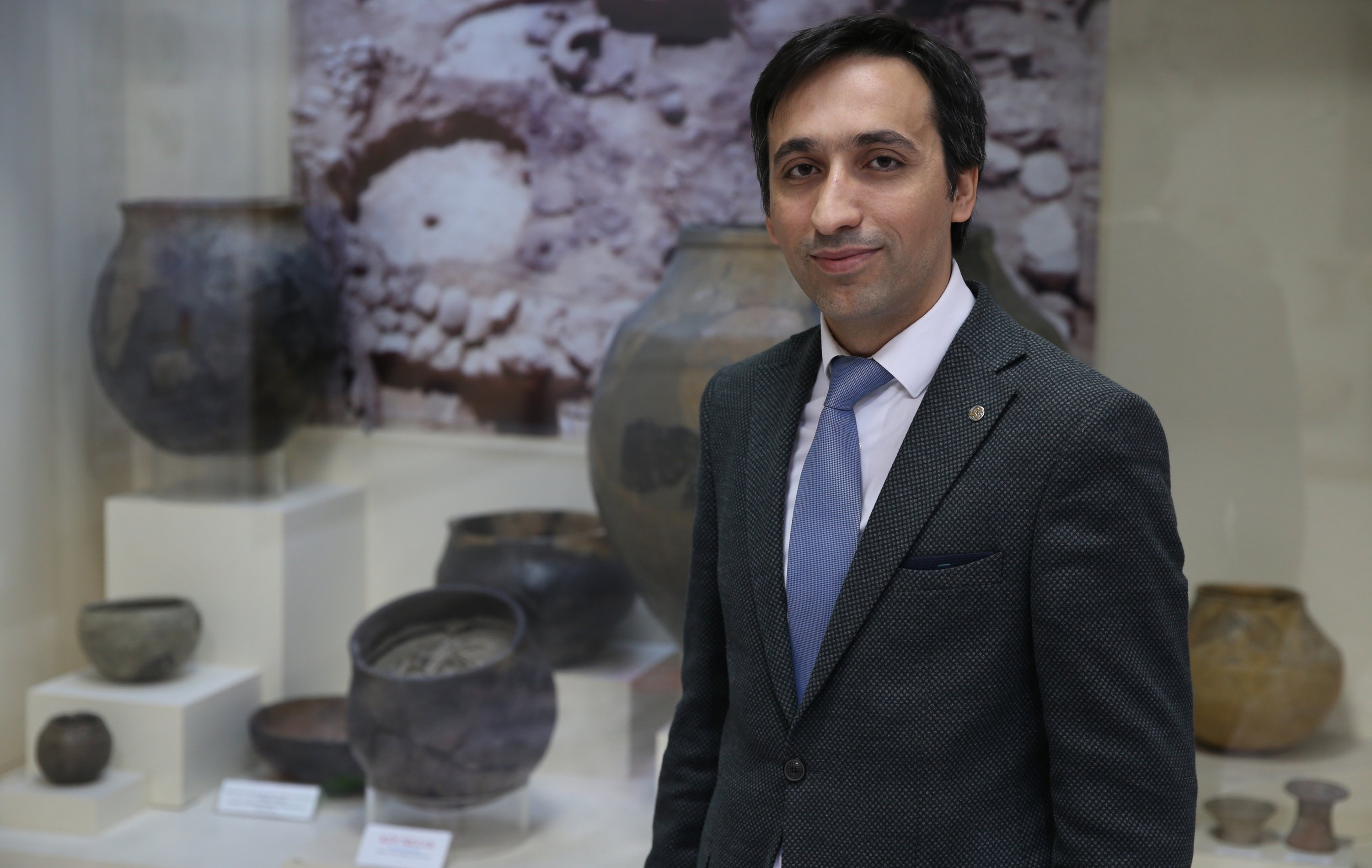Direktur Museum Malatya Samet Erol berpose di dekat makam kubus berusia 5.000 tahun yang berisi kerangka bayi yang ditemukan selama penggalian di Arslantepe Mound, Malatya, Turki, 16 Mei 2022. (AA Photo)