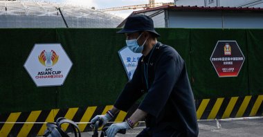 A man cycles past the construction site of the Workers&#039; Stadium, a planned venue for the 2023 Asian Cup, Beijing, China, May 14, 2022. (AFP Photo)