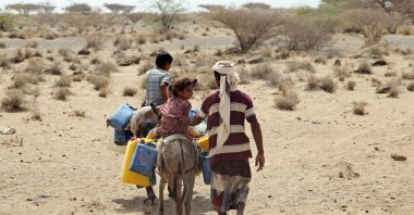 Yemenis commute on donkeys carrying jerrycans at a makeshift camp for people who fled fighting between Houthi rebels and the Saudi-backed government forces, in the village of Hays in the western province of Hodeida, Yemen, May 17, 2022. (AFP Photo)