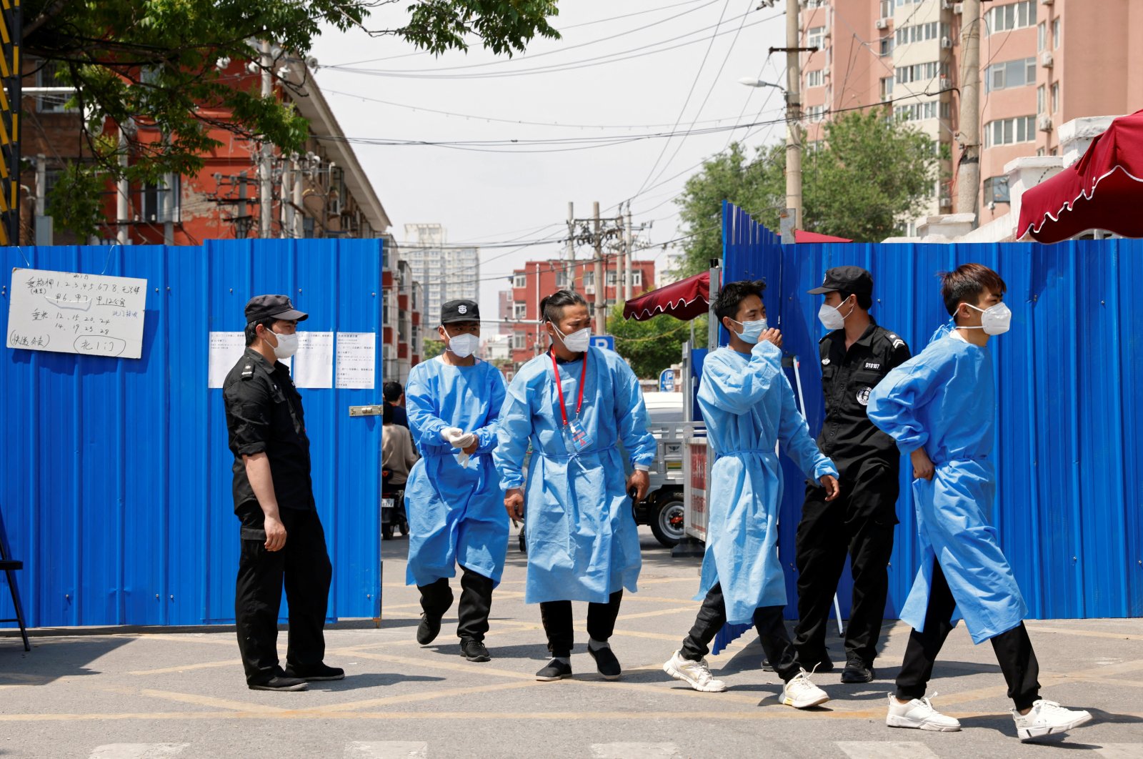 Workers in protective suits walk through the gate of a barricaded residential area under lockdown amid the COVID-19 outbreak, Beijing, China, May 17, 2022. (Reuters Photo)