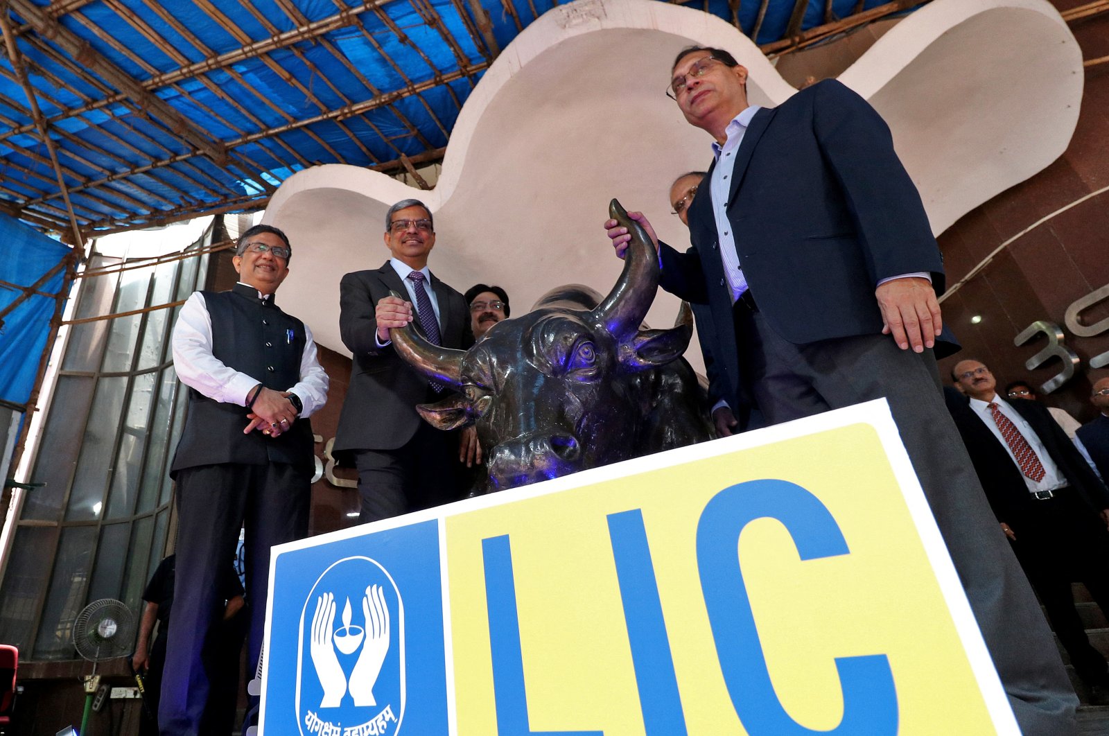From left to right, Ashishkumar Chauhan, managing director and CEO of the Bombay Stock Exchange (BSE), Life Insurance Corporation of India (LIC) Chairperson Mangalam Ramasubramanian Kumar and Tuhin Kanta Pandey, secretary of the Department of Investment and Public Asset Management (DIPAM), pose with a bronze replica of the Charging Bull of Wall Street, after the company&#039;s IPO listing ceremony at the Bombay Stock Exchange (BSE) in Mumbai, India, May 17, 2022. (Reuters Photo)