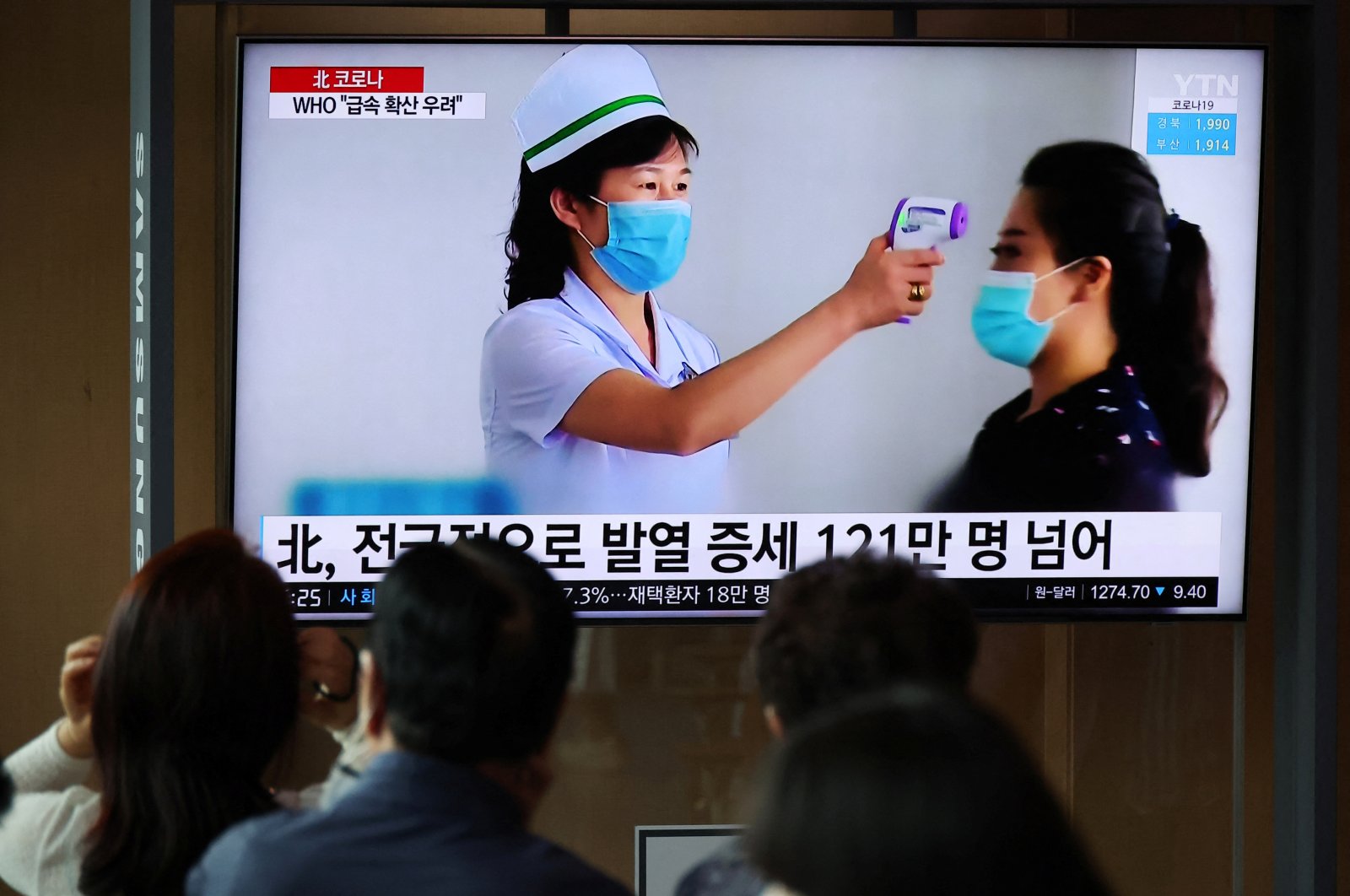 People watch a TV broadcasting a news report on the coronavirus outbreak in North Korea, at a railway station in Seoul, South Korea, May 17, 2022. (Reuters Photo)
