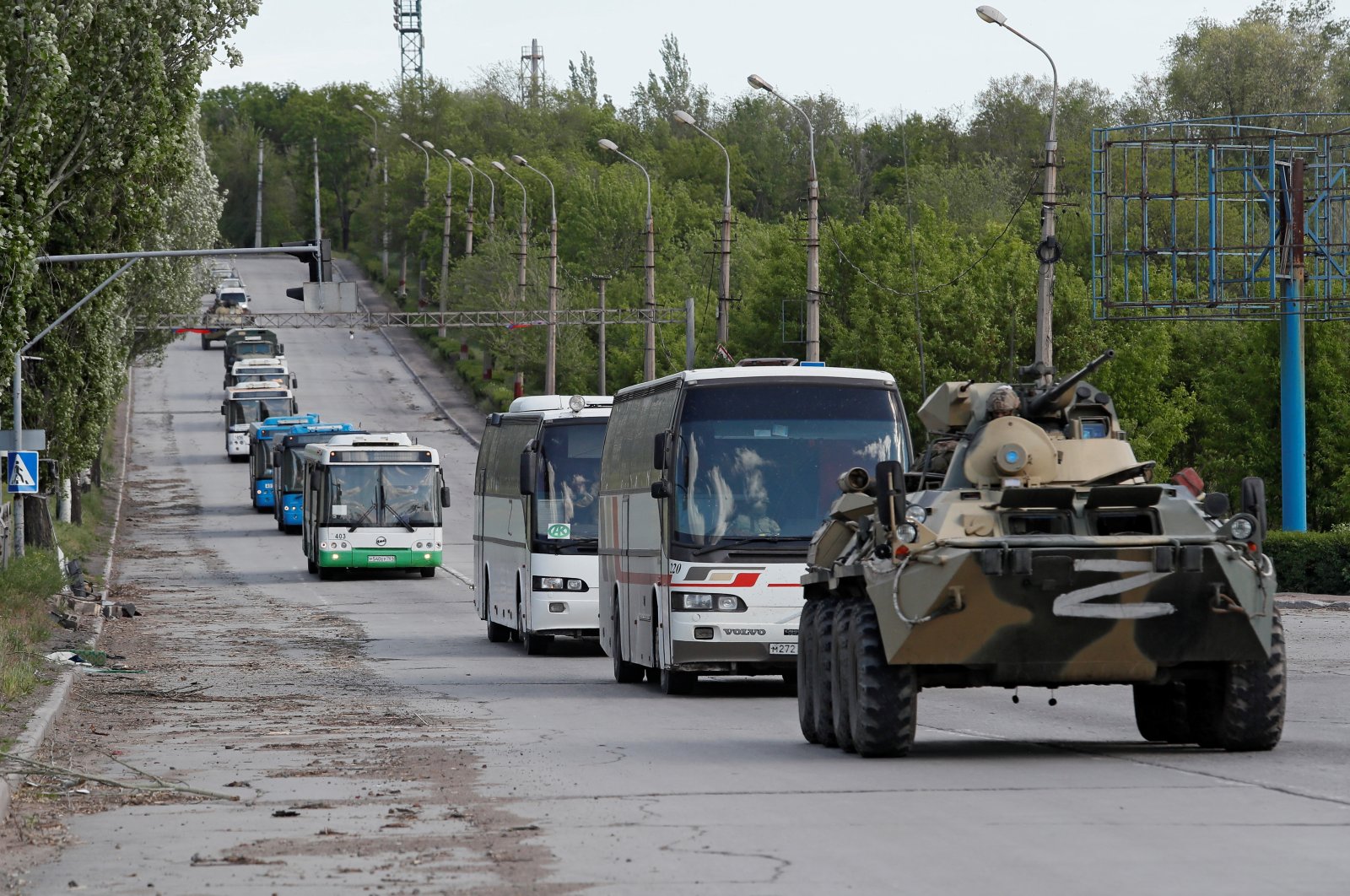 Buses carrying Ukrainian forces who have surrendered after weeks holed up at the Azovstal steelworks drive away under the escort of the pro-Russian military forces in the course of the Ukraine-Russia conflict in Mariupol, Ukraine, May 17, 2022. (REUTERS Photo)