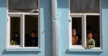 Boys look out from the window sill of a school that was damaged during the conflict between the Taliban and Afghanistan's former ruling government, Kandahar, Afghanistan, May 12, 2022. (AFP Photo)