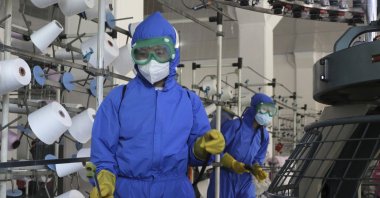 Employees of Songyo Knitwear Factory in Songyo district disinfect the work floor in Pyongyang, North Korea, May 18, 2022. (AP Photo)