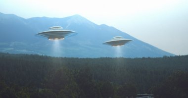 Illustration of two UFOs hovering over a road. (Shutterstock Photo)