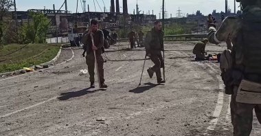Ukrainian service members are walking toward pro-Russian military personnel as they leave the besieged Azovstal steel plant in Ukraine's port city of Mariupol, May 17, 2022. (AFP Photo)