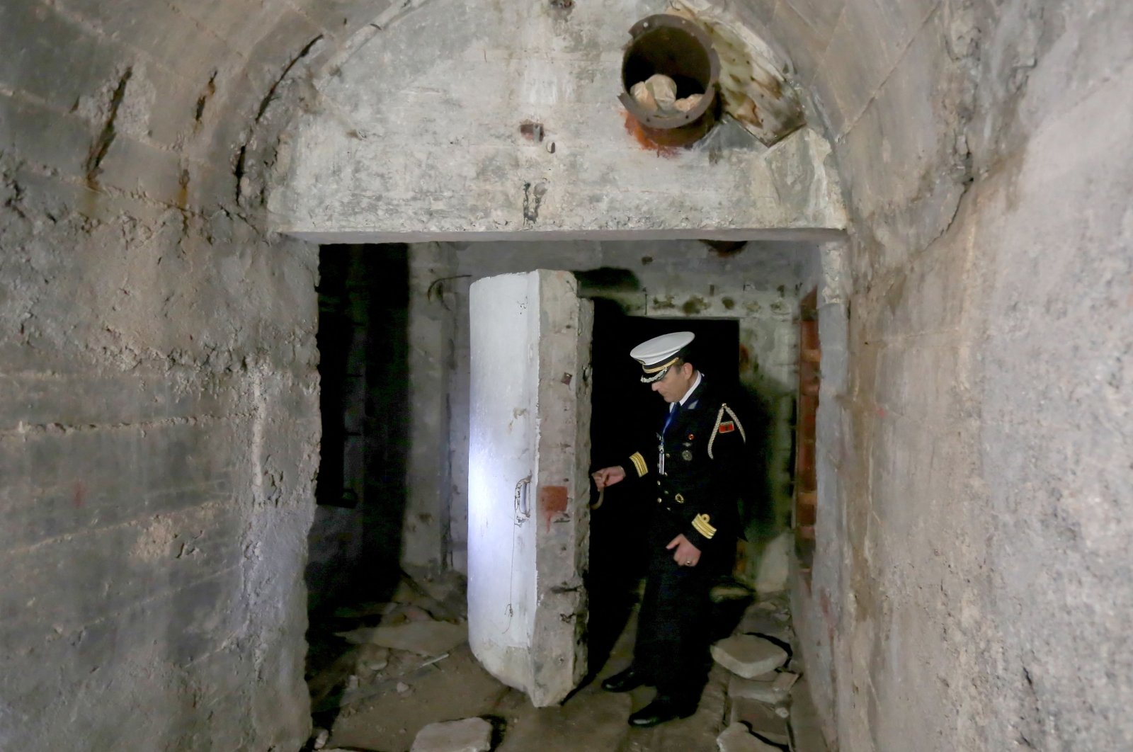 Capt. Eduart Jeminaj opens one of the gates to the tunnel of the base near the city of Himara, Albania, April 27, 2022. (AFP Photo)