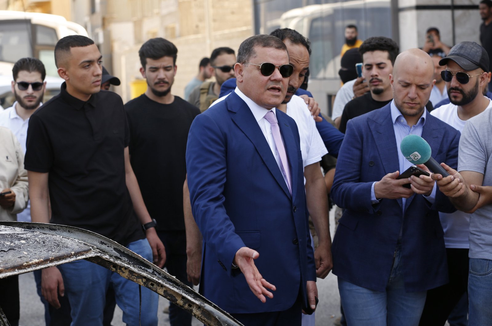 Abdul Hamid Dbeibah, one of Libya’s two rival prime ministers (C) speaks to residents as he visits a Tripoli neighborhood after competing militias fought there, in Tripoli, Libya, May 17, 2022. (AP Photo)