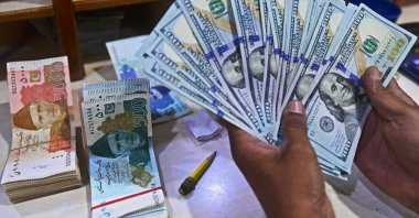 A foreign currency dealer counts U.S. dollars at a shop in Karachi, Pakistan, May 19, 2022. (AFP Photo)