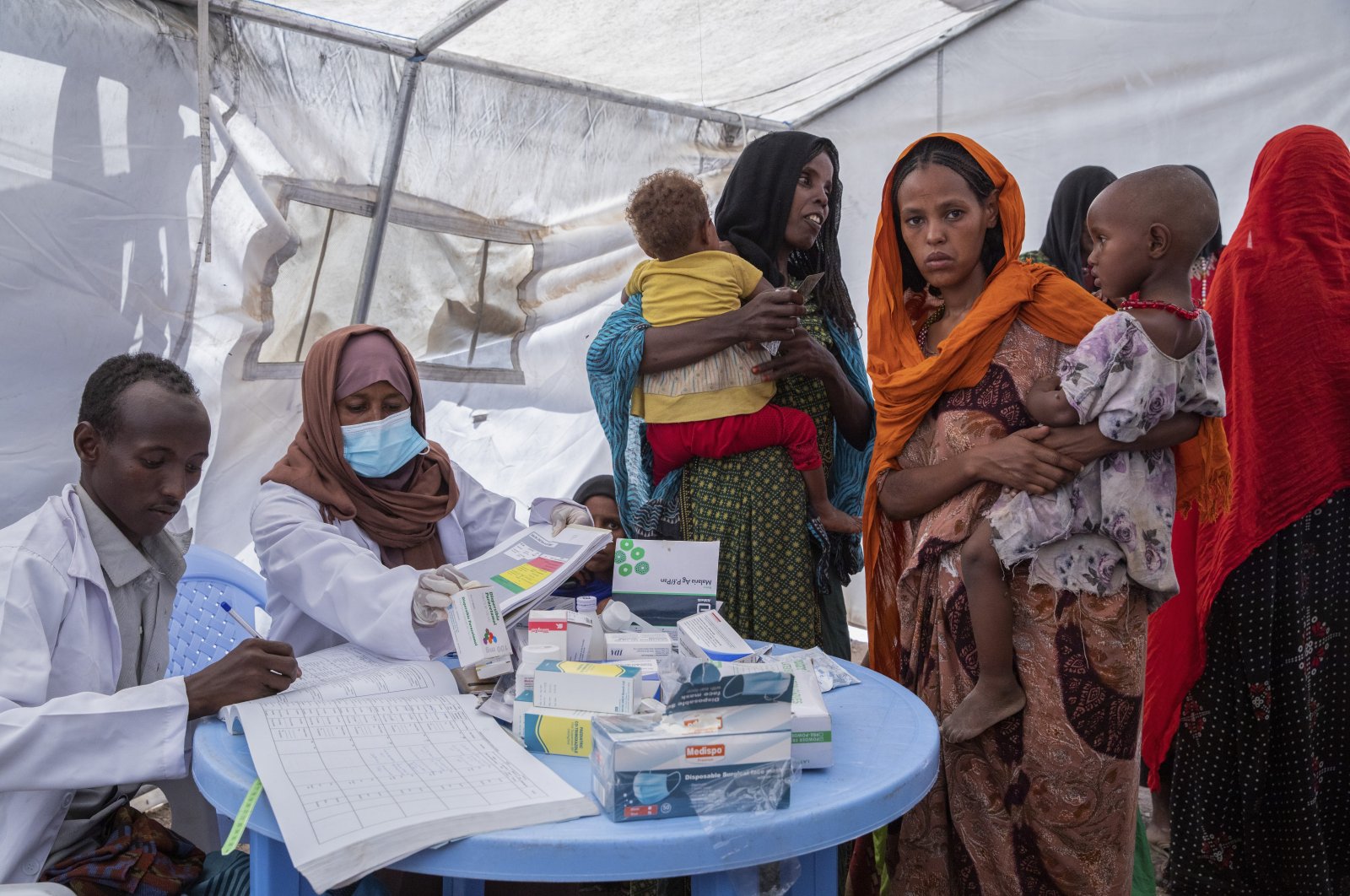 In this photo released by UNICEF, a mobile health and nutrition team attends to displaced mothers and their children at the Guyah site for internally displaced people in the Afar region of Ethiopia, May 10, 2022. (UNICEF via AP)
