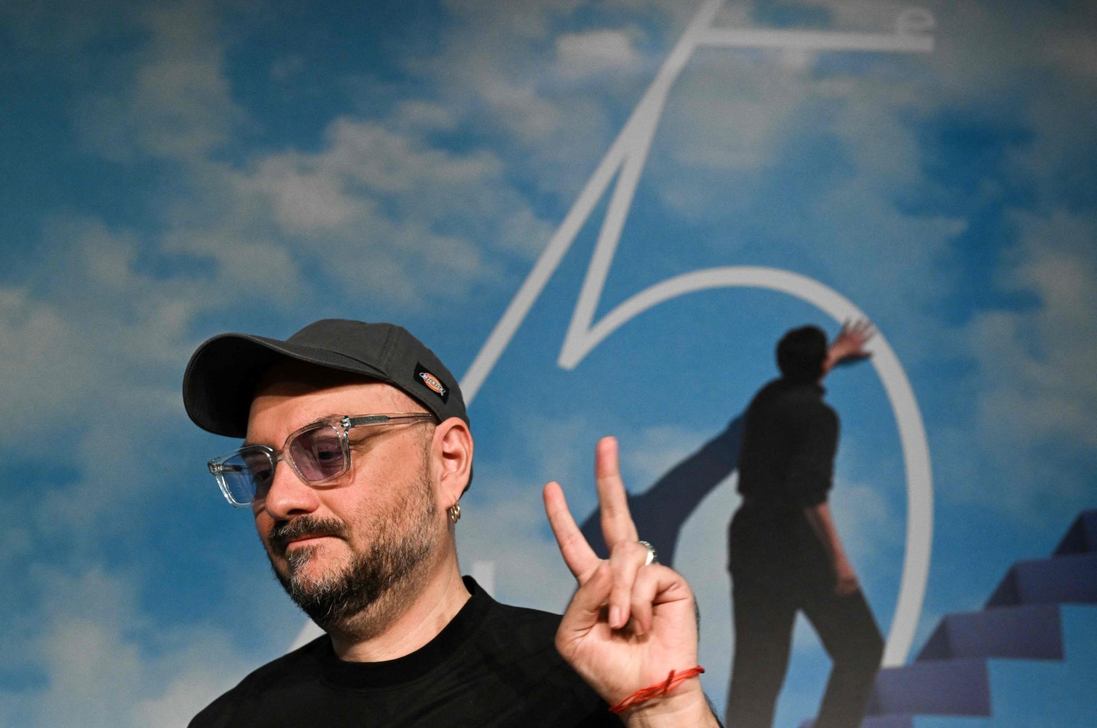 Russian director Kirill Serebrennikov flashes the victory sign as he arrives to attend a press conference for the film &quot;Tchaikovsky&#039;s Wife&quot; (&quot;Zhena Chaikovskogo&quot;) at the 75th edition of the Cannes Film Festival in Cannes, southern France, on May 19, 2022. (AFP)