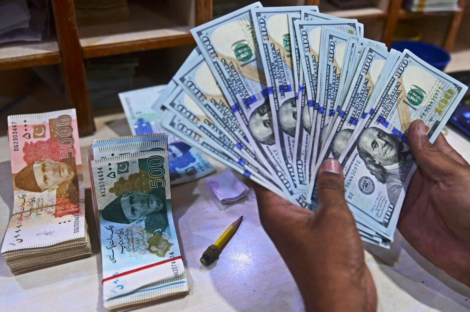 A foreign currency dealer counts U.S. dollars at a shop in Karachi, Pakistan, May 19, 2022. (AFP Photo)