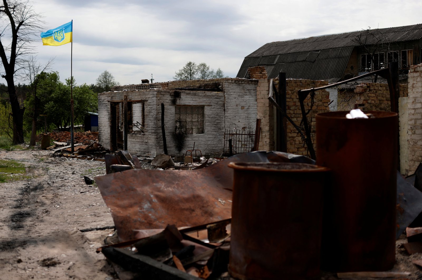 A Ukrainian flag flutters next to a destroyed house in Moshchun village, amid Russia's invasion, Kyiv region, Ukraine May 19, 2022. REUTERS/Edgar Su