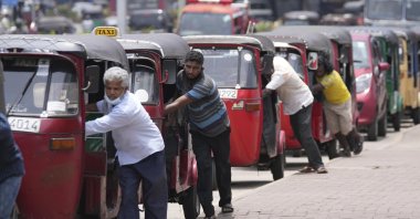 Sri Lankan auto-rickshaw drivers queue up to buy petrol near a fuel station in Colombo, Sri Lanka, April 13, 2022. (AP Photo)