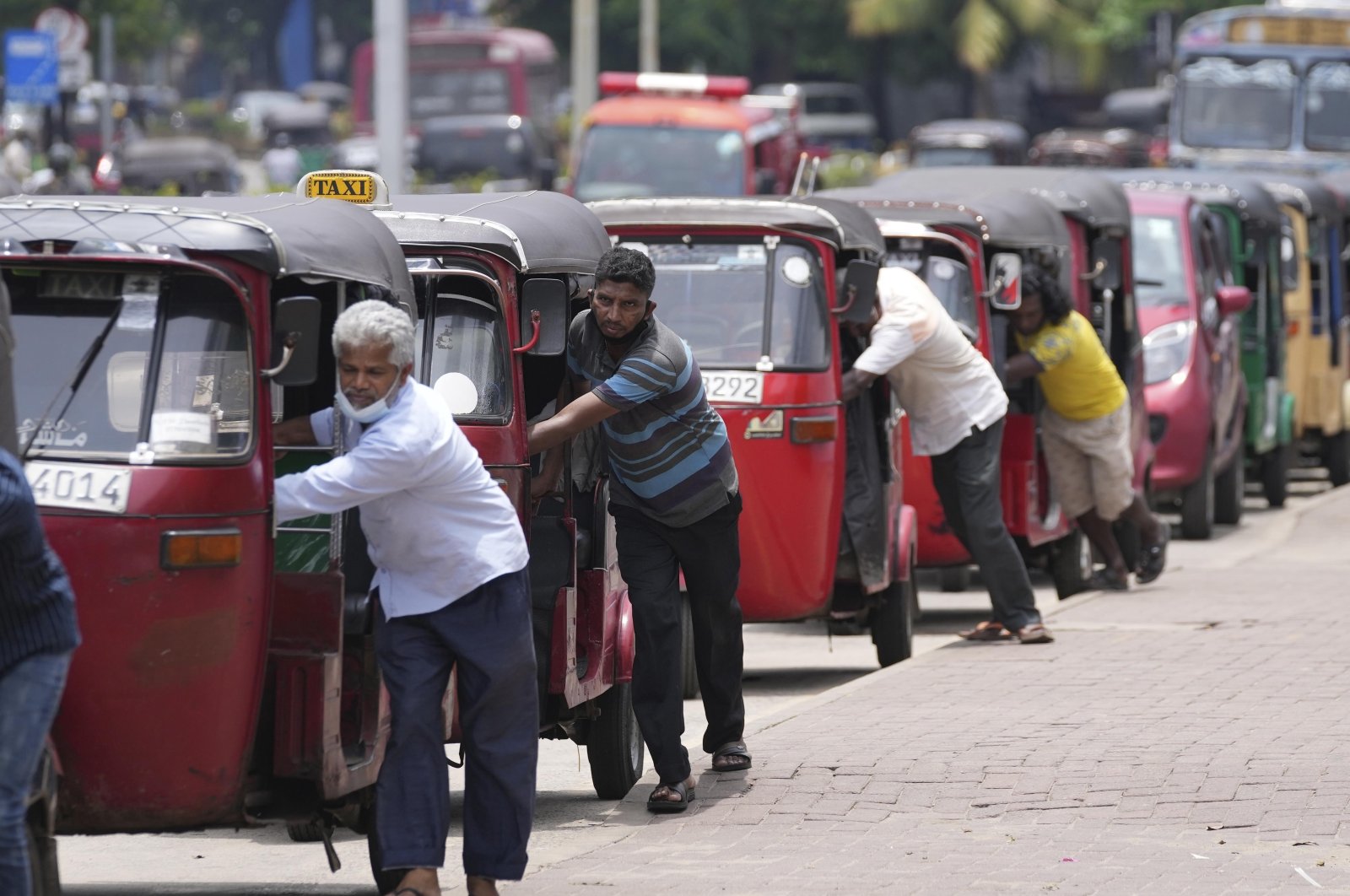 Sri Lankan auto-rickshaw drivers queue up to buy petrol near a fuel station in Colombo, Sri Lanka, April 13, 2022. (AP Photo)