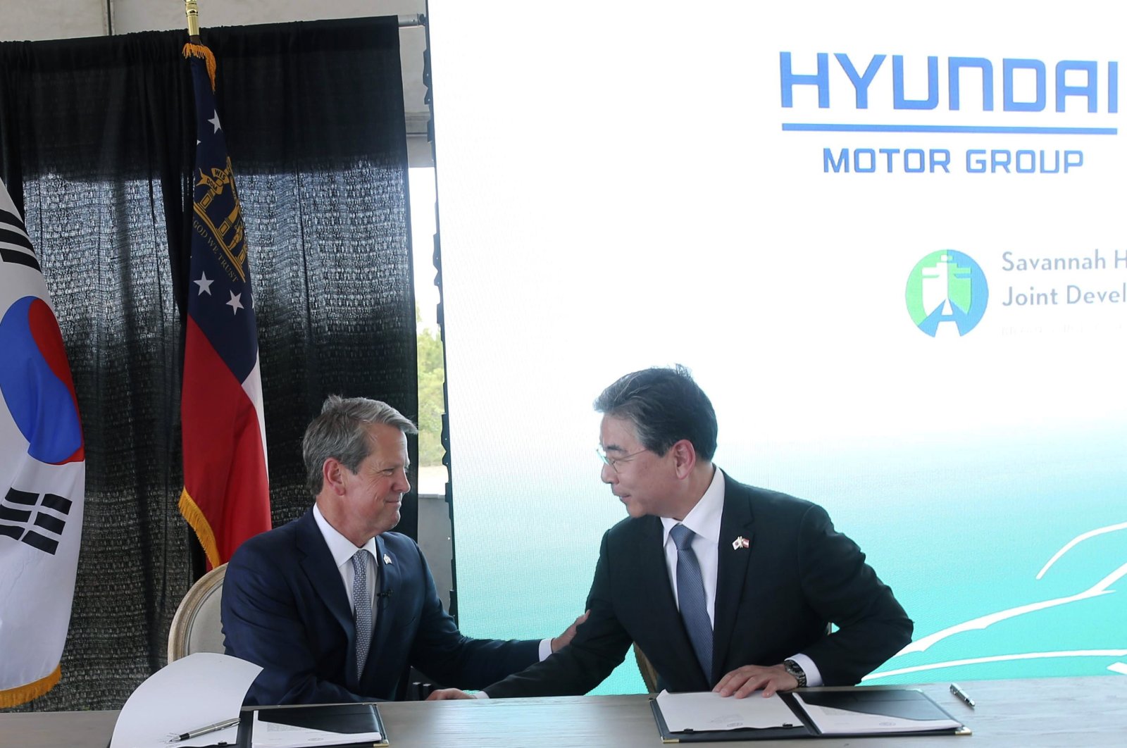 Georgia Governor Bran Kemp (L), and Jaehoon "Jay" Chang, Hyundai Motor Company president and CEO, shake hands after signing an agreement to finalize a deal for Hyundai Motor Group to build a manufacturing plant, Georgia, U.S., May 20, 2022. (AP Photo)