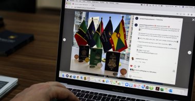 Jose Charo, head of the Beirut office of Passport Legacy, a Swiss-based company specializing in the industry of residency and citizenship by investment programs, shows the website of his company at his office in the Lebanese capital, April 12,  2022. (AFP Photo)