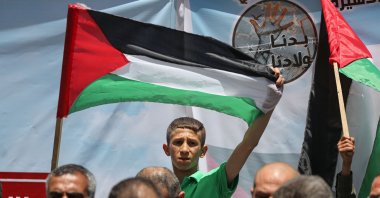 A child holds the Palestinian flag in a demonstration organized to deliver the bodies of Palestinian prisoners who lost their lives in Israeli prisons to their families in Gaza, Palestine, May 22, 2022. (AA Photo)