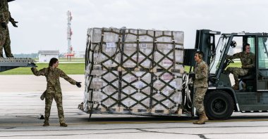 Airmen unload pallets from the cargo bay of a U.S. Air Force C-17 carrying 78,000 lbs of Nestlé Health Science Alfamino Infant and Alfamino Junior formula from Europe at Indianapolis Airport on May 22, 2022. (AFP Photo)