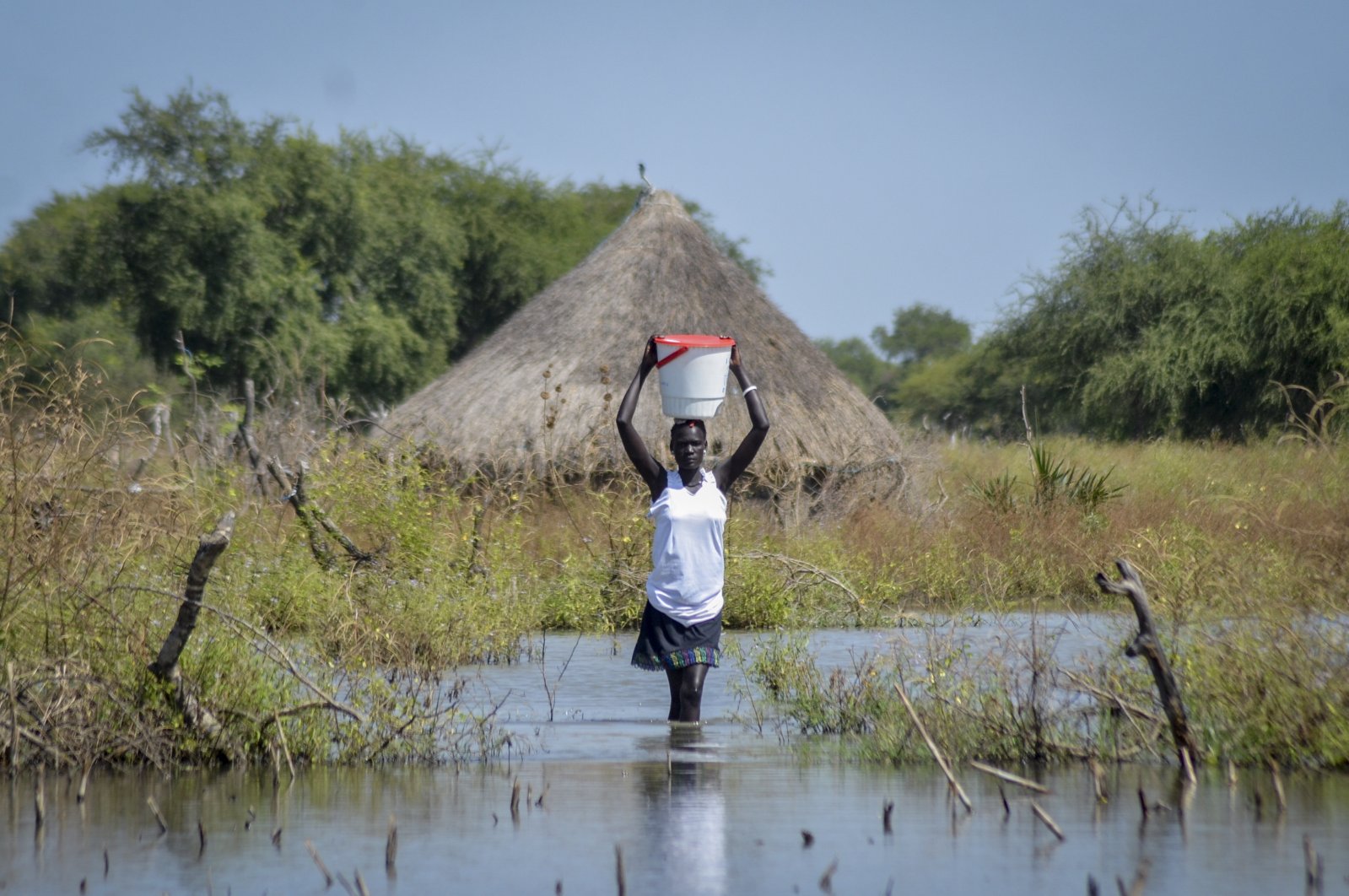 A woman carries a bucket on her head as she wades through floodwaters in the village of Wang Chot, Old Fangak county, Jonglei state, South Sudan, Nov. 26, 2020. (AP File Photo)
