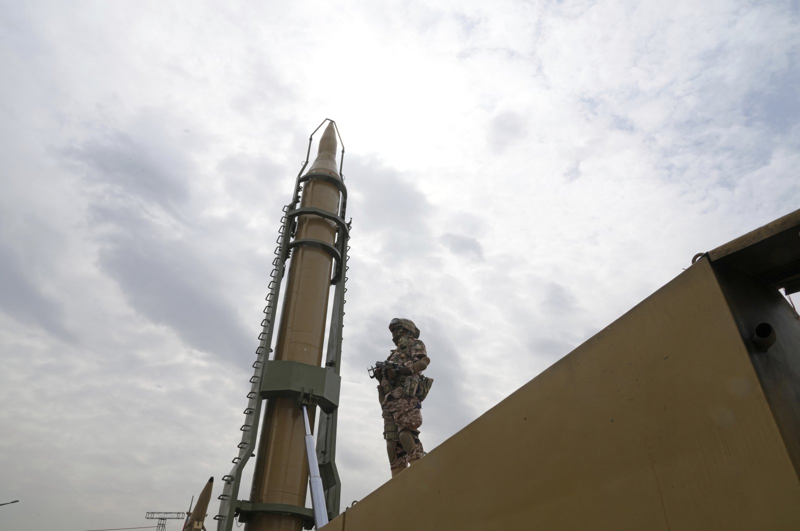 A member of the Revolutionary Guard stands in front of Shahab-3 missile which is displayed during an annual rally in Tehran, Iran, Friday, April 29, 2022. (AP File Photo)