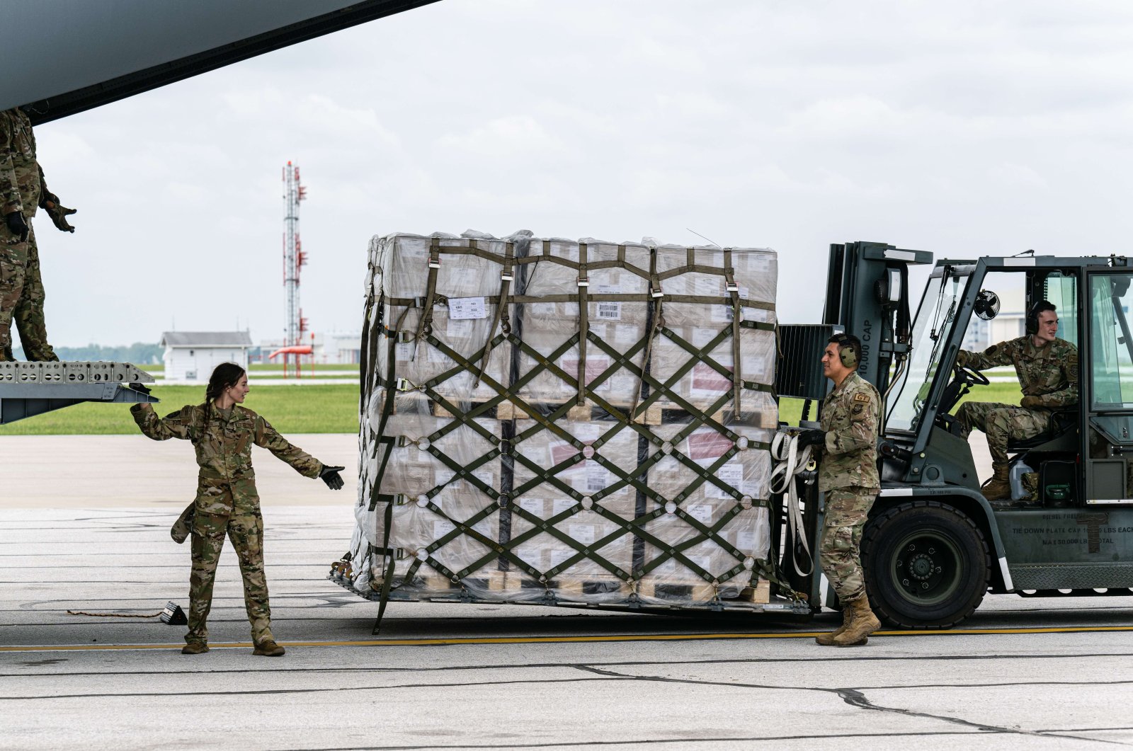 Airmen unload pallets from the cargo bay of a U.S. Air Force C-17 carrying 78,000 lbs of Nestlé Health Science Alfamino Infant and Alfamino Junior formula from Europe at Indianapolis Airport on May 22, 2022. (AFP Photo)