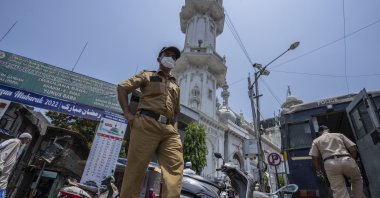 Police officers patrol outside a mosque as a man arrives to offer afternoon prayers in Mumbai, India, May 4, 2022. (AP Photo)