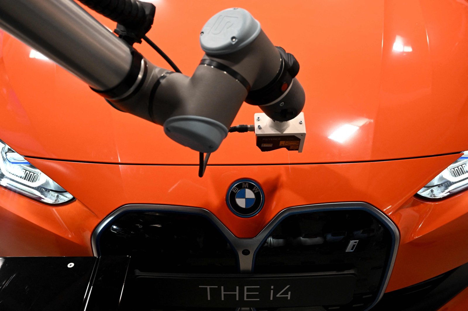 A robot takes over the quality check of a new BMW i4 car presented during an event marking the 100th anniversary of the BMW plant in Munich, southern Germany, May 20, 2022. (AFP Photo)