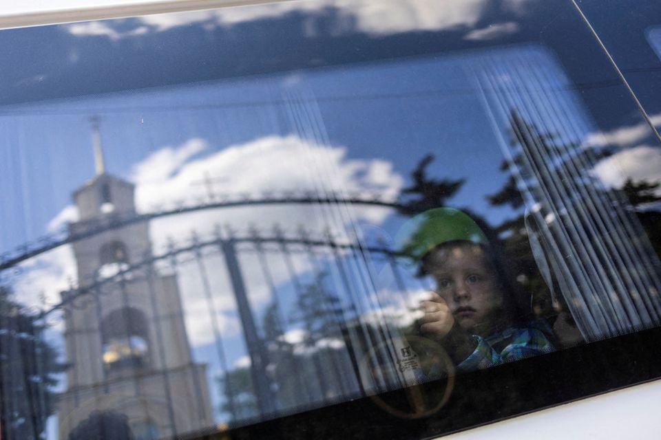 A boy looks through the window of a minibus as he and his family are being evacuated, Donetsk region, Ukraine, May 23, 2022. (Reuters Photo)