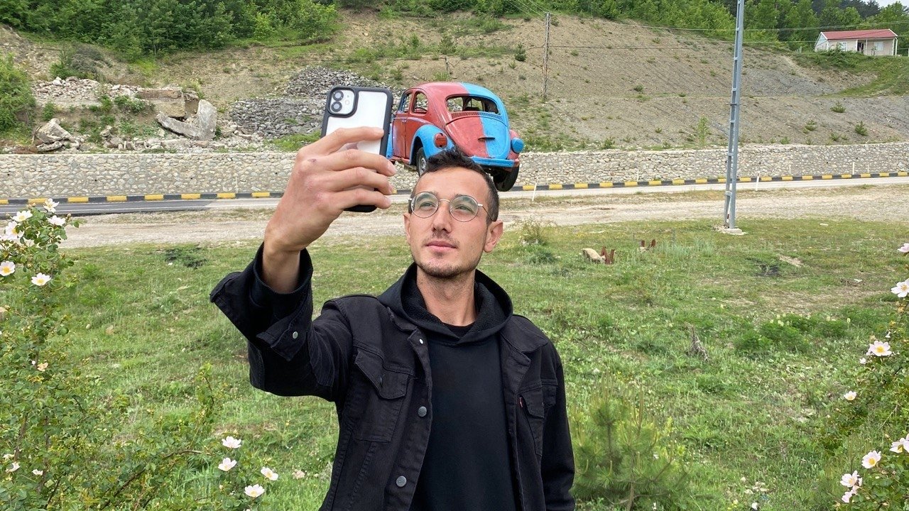 A young man at the village of Ovacuma taking a selfie with the "Vosvos" VW Beetle painted in Trabzonspor&#039;s colors, Safranbolu, Karabük, northern Turkey, May 24, 2022. (IHA Photo)