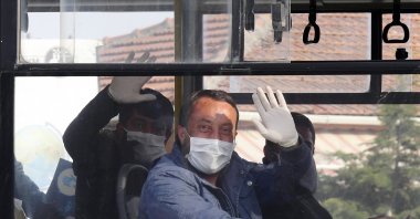 Prisoners released wave as they sit in a bus, in the capital Ankara, Turkey, April 15, 2020. (AP PHOTO)