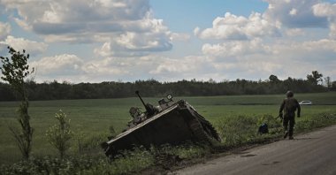 A Ukrainian officer walks next to a damaged Ukrainian armored vehicle outside the city of Lysychansk in Donbass, Ukraine, May 23, 2022. (AFP Photo)
