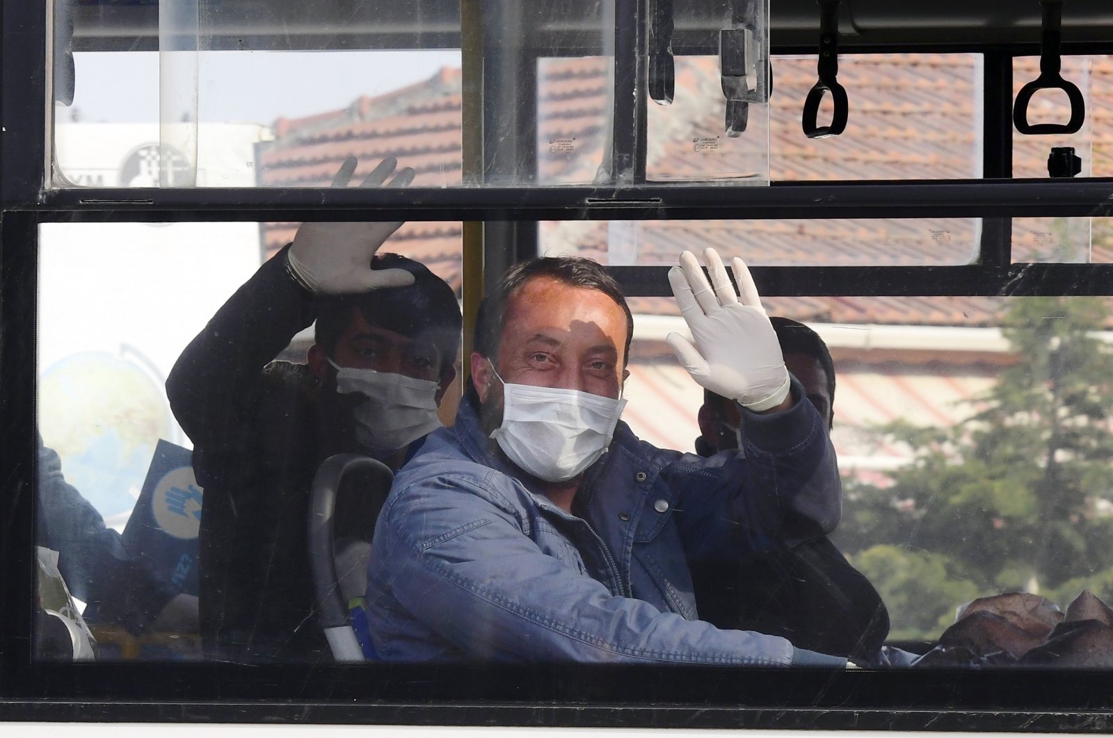 Prisoners released wave as they sit in a bus, in the capital Ankara, Turkey, April 15, 2020. (AP PHOTO)